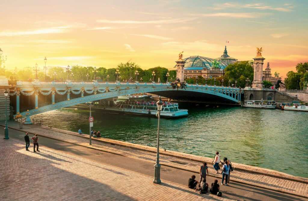 Embankment near bridge of Alexandre III in Paris at sunset